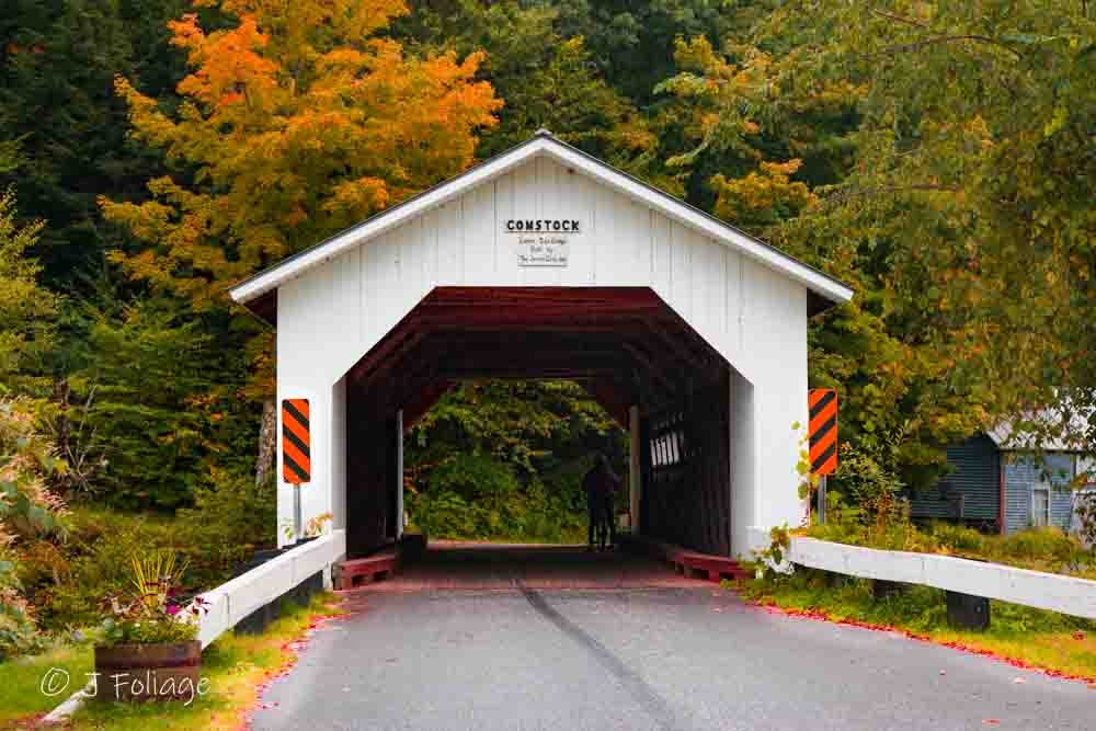 The Comstock Covered Bridge with a cyclist waiting out a rain shower inside the wooden structure