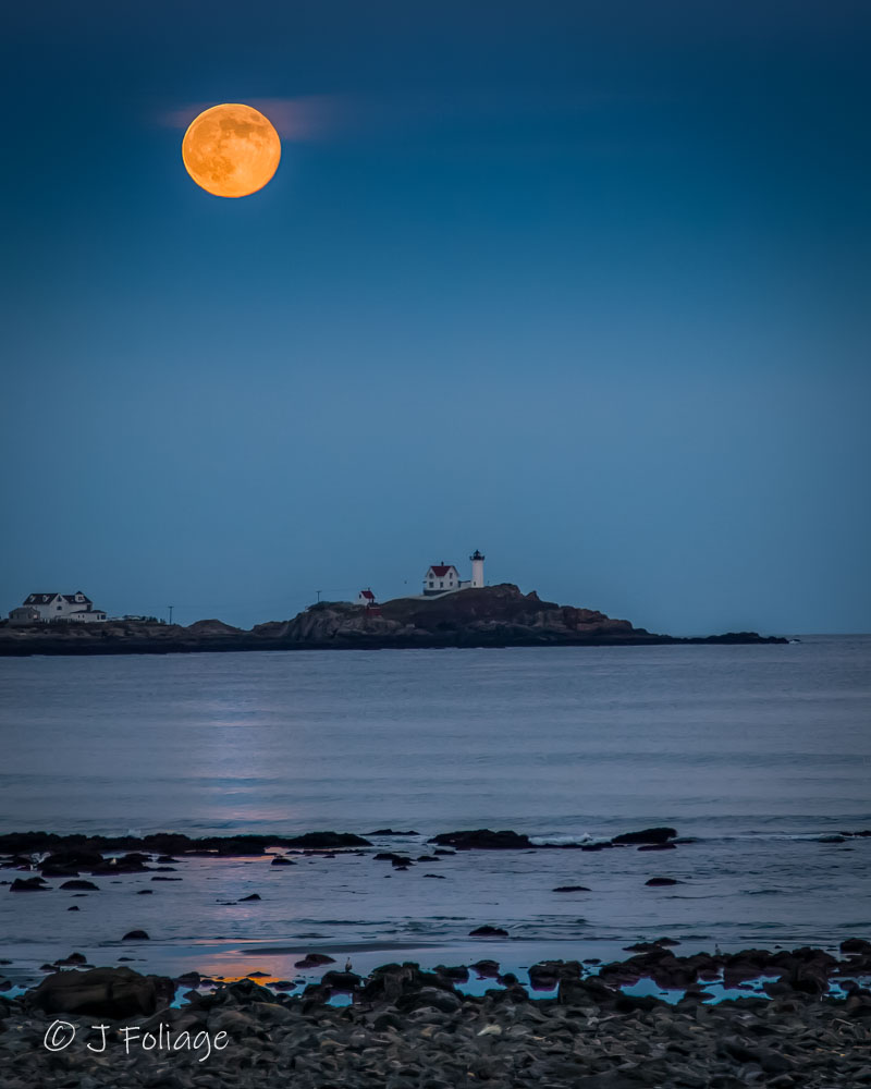 Nubble Lighthouse view from Shore Road in York Maine featuring the rocky northern coastline Full moon rising over Nubble Lighthouse viewed from Long Sands Beach in York Maine