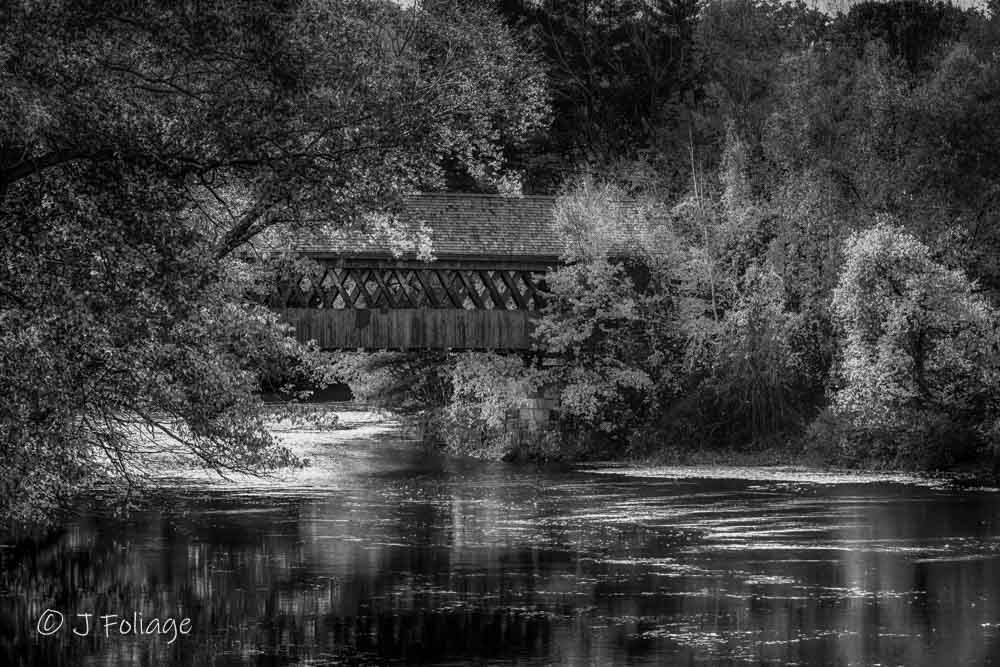 Timeless black and white capture of the Henniker Covered Bridge over the Contoocook River in New Hampshire.
