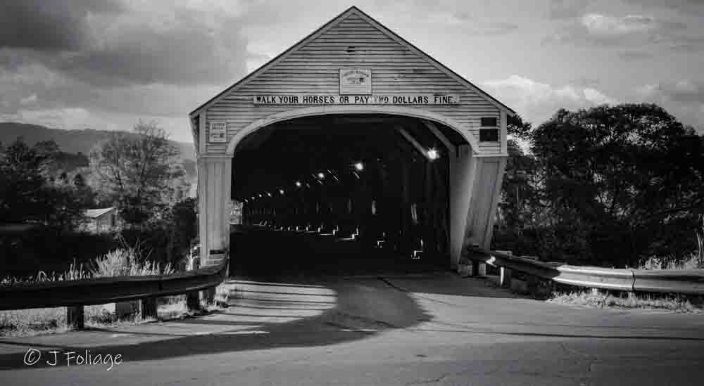 The Cornish–Windsor Covered Bridge in black and white, showing the repeating timber beams of the longest wooden bridge in the U.S.