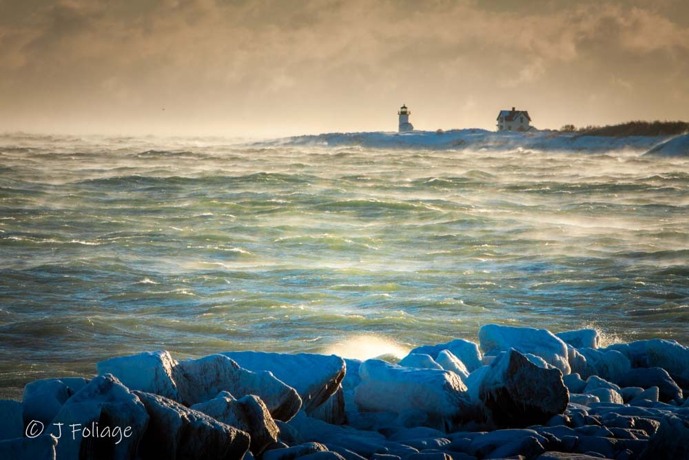 Distant view of Straitsmouth Lighthouse in Rockport surrounded by low-lying sea smoke on a frigid morning