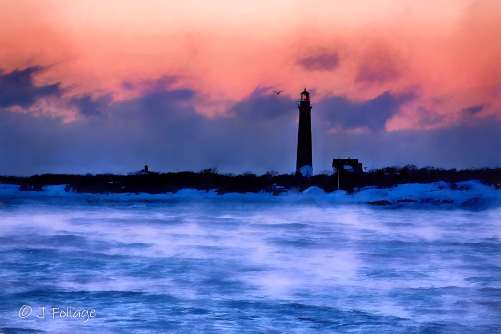 Aerial view of Thacher Island Twin Lighthouses peeking through a thick layer of arctic sea smoke