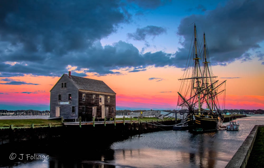 Fine art photography of Derby Wharf in Salem MA at sunset, featuring the historic Friendship of Salem tall ship and Pederick Storehouse for maritime-themed interior design.